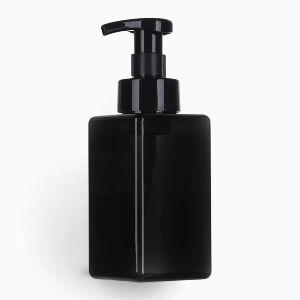 Distributeur savon mousse compact aux couleurs variées posé près d'un évier de salle de bain