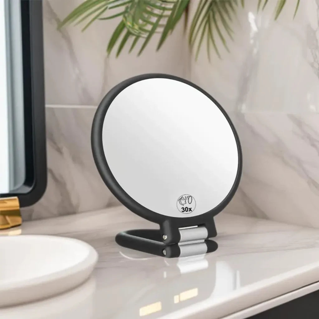 Miroir grossissant de voyage posé sur le plan de toilette d'une salle de bain