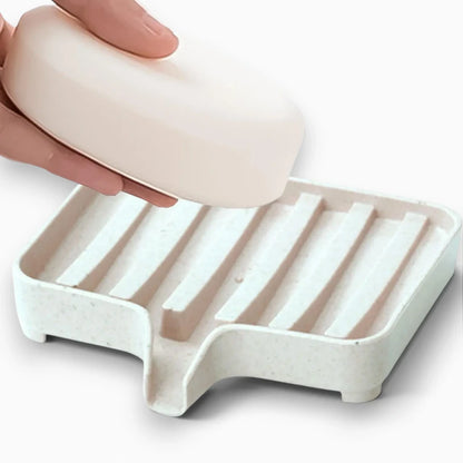 Support porte-savon pour barre de douche permettant l'écoulement de l'eau