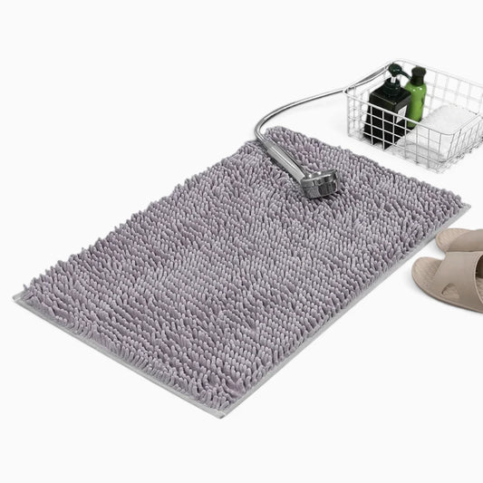 Tapis de bain chenille moelleux en teinte neutre posé devant une douche