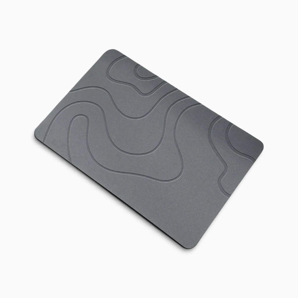 Tapis de bain design en diatomite absorbant l'eau devant une douche