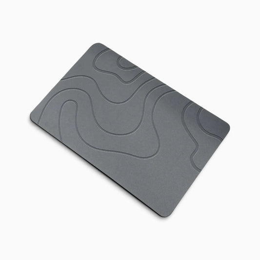 Tapis de bain design en diatomite absorbant l'eau devant une douche